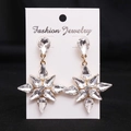 Macro shot of silver snowflake earrings with white crystals on a jewelry display card - Gold Plated (White Zircon)