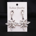 Close-up of alloy snowflake earrings with clear pear-shaped crystals on display card - Silver (White Zirconia)