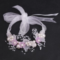 Detailed macro view of white organza ribbon with pearls and pink flowers hairband - Purple Bracelet