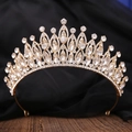 Primo piano di una corona da sposa dorata con strass di cristallo su superficie scura - Oro Zircone Bianco