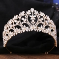 Dettaglio di corona dorata con motivi floreali intricati e strass scintillanti - Oro KC con strass bianchi