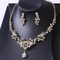Macro shot of bridal crystal necklace set with pear-cut rhinestones on black bust - Gold White Zirconia
