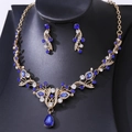 Detail view of gold bridal jewelry set with navy blue crystals and floral leaf patterns - Gold Base Royal Blue Zirconia