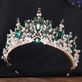 Makroaufnahme der goldenen Barockkrone mit Smaragdkristallen und Strass auf Holz - Handgemacht / Gold mit grünem Stein