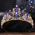 Close-up of golden crown featuring deep blue teardrop rhinestones and intricate metalwork - KC Gold White & Sapphire Blue Rhinestone