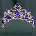 Close-up of golden crown featuring large blue crystals and intricate diamond settings - KC Gold White & Sapphire Blue Rhinestone