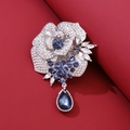 Macro-opname van een zilveren roosbroche met diepblauwe kristallen en druppelvormige hanger - Zilveren Blauwe Edelsteen Stijl (XZ005)