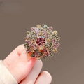 Gros plan d'une broche pissenlit avec des strass roses et champagne à la main - Pissenlit Coloré (X0199)