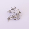 Detailopname van de zilveren paardenhoofd speld met witte kristallen en zwart oogje - Zilver