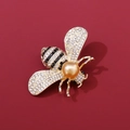 Dettaglio macro di spilla ad ape dorata con strass bianchi e perla dorata centrale - Ape Dorata Perla Artificiale Gialla