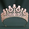 Macro detail of golden baroque crown with pink teardrop gemstones and white crystals - Gold/Pink