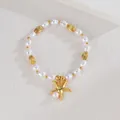 Detail of elegant pearl bracelet featuring a golden starfish pendant and textured metal beads - Starfish