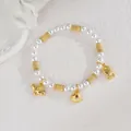 Détail d'un bracelet de perles avec breloques dorées en forme de tortue, coquillage et poisson - Coquillage Poisson Tortue