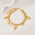 Primer plano de la pulsera bañada en oro 18KGP con dijes de circonita y colgantes de hoja - Dorado