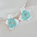 Detalle de pendientes florales con esmalte verde menta y cristales centrales - Azul
