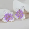 Primer plano detallado de pendientes de flores esmaltadas en violeta y blanco con cristales - Morado