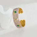 Détail d'un bracelet doré vintage avec émail marbré lavande et motifs floraux incrustés - Vert