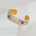 Détail d'un bracelet manchette en émail floral avec motifs dorés gaufrés sophistiqués - Violet foncé