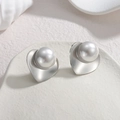 Vue macro de boucles d'oreilles cœur argentées avec perles sur un plateau céramique - Style Perle Cœur (S-E1063) / Couleur Acier