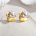 Détail macro de boucles d'oreilles cœur en or mat avec une grande perle blanche lisse - Style Perle Cœur (S-E1063) / Doré