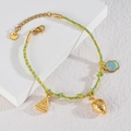 Detail eines geflochtenen Seilarmbands mit goldenen Fruchtanhängern und Edelstahlverschluss - Erdbeere + Wassermelone