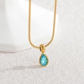 Macro shot of gold teardrop pendant with blue zircon stone on minimalist snake chain - Lake Blue