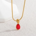 Macro shot of gold teardrop necklace with red zircon stone and sleek snake chain - Red