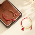 Détail de créoles en perles avec pendentifs rouges de poulpe, hippocampe et corail - Rouge