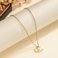 Close-up of golden necklace with star pendant and textured pearl charm on minimalist stand - Star Irregular Artificial Pearl Style (S-N2241-F)