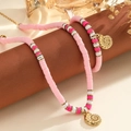 Gros plan du collier en perles Heishi roses et blanches avec pendentif coquillage doré - Bracelet Rose