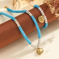 Vue détaillée des pendentifs coquillage dorés sur l'ensemble de bijoux en perles boho - Bracelet Bleu