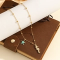 Collar de cuentas doradas con dijes de estrella de mar y caballito sobre cuaderno - Estilo Caballito de Mar y Estrella de Mar (S-N2276-B)