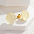Macro shot of semi-translucent pale yellow resin stud earrings with subtle gold shimmer - Yellow