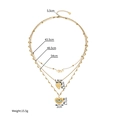 Collana multistrato dorata con ciondoli a cuore e simbolo dell'occhio su fondo bianco - Collana a Tre Strati Cuore Malocchio (SFLN2270)