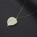 Elegante collana con pendente a foglia d'oro e venature in filigrana su sfondo nero scuro - Grande Oro (NST-0443-Foglia d'Oro Grande)