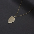 Dettaglio macro del ciondolo a foglia dorata con intricate trame di venature naturali - Piccolo Oro (NST-0443-Foglia d'Oro Piccola)