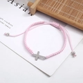 Detail of pink hand-woven bracelet featuring a silver cross charm and adjustable cord - Pink