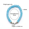 Elastic beaded bracelet with 6mm light blue glass beads and a white cross pendant - Light Blue (BNS-0609-1 [Eco-friendly])