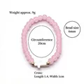 Pink glass bead stretch bracelet featuring a white cross charm and gold accents - Pink (BNS-0609-7 [Eco-friendly])