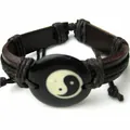 Dettaglio macro di un bracciale in pelle intrecciata con simbolo Yin Yang Tai Chi - Rotondo
