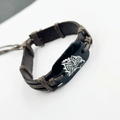 Dettaglio del bracciale vintage in pelle con totem lupo e luna e corda di cotone intrecciata - Testa di Lupo Pelle Marrone