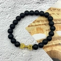 Macro detail of beaded fitness bracelet with black matte stones and golden dumbbell charm - Matte Stone Gold