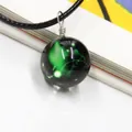 Macro shot of galaxy glass ball necklace with green nebula effect and black wax cord - Aries