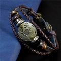 Vue macro d'un bracelet multicouche en cuir Cancer avec charme en métal bronzé - Cancer