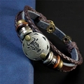 Gros plan détaillé du bracelet en cuir tressé marron avec plaque en métal Taureau - Taureau