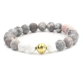 Matte zebra stone and volcanic rock beaded bracelet with a polished gold metal charm - Gold