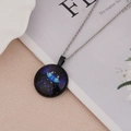 Macro-opname van zilveren Gemini-sterrenbeeldketting met lichtgevende glazen hanger - Tweelingen