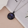 Detail view of a luminous Libra constellation necklace pendant on a white magazine base - Libra