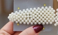 Elegant water drop shaped hair clip featuring dense white pearls on a display card - Triangle Full