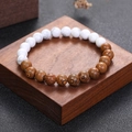 Elastic bead bracelet with white marble stone and wenge wood beads on wooden display - White Turquoise And Wood Grain